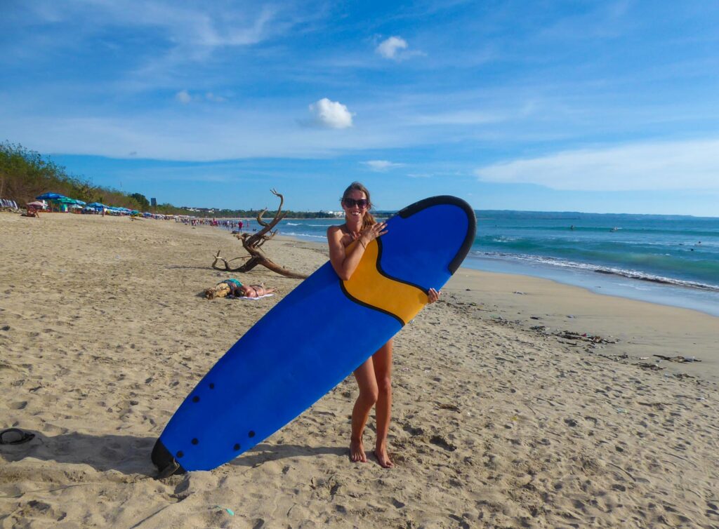 anna with surf board on kuta beach, bali